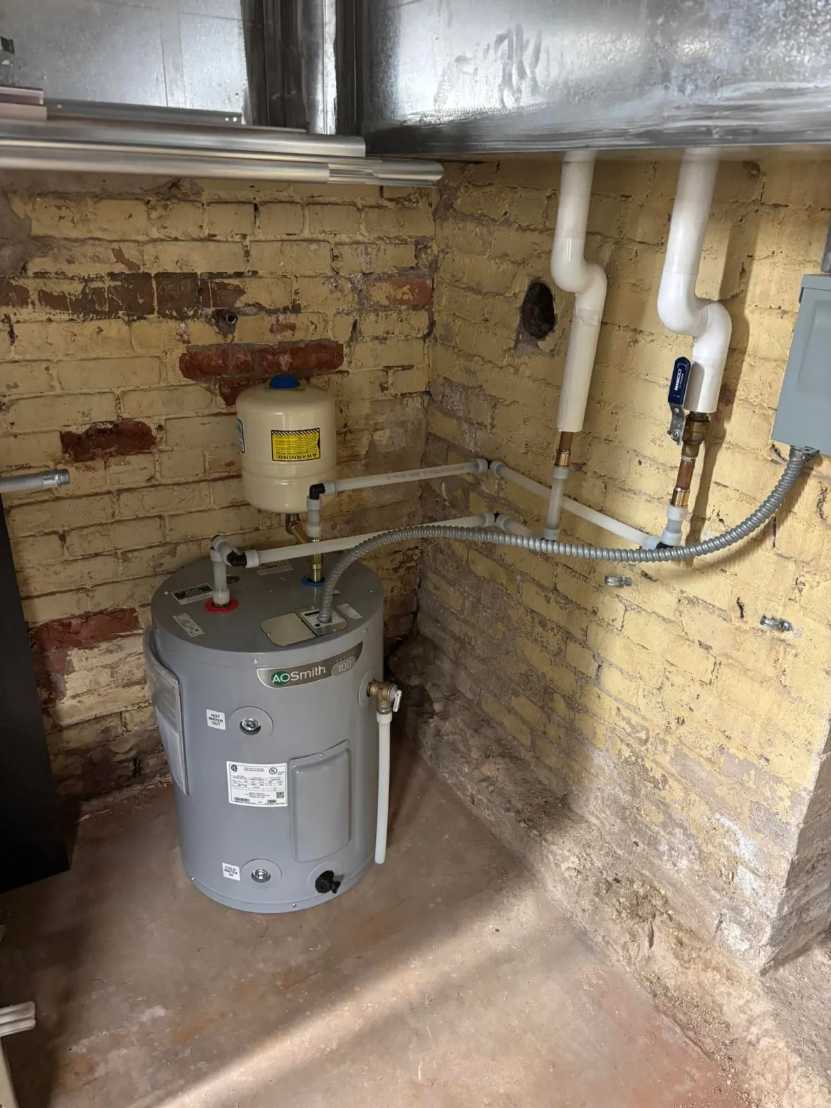 Installed tank water heater with expansion tank and supply piping